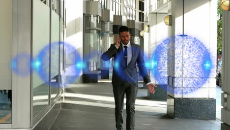 animation of blue spots moving over caucasian businessman talking on smartphone in office