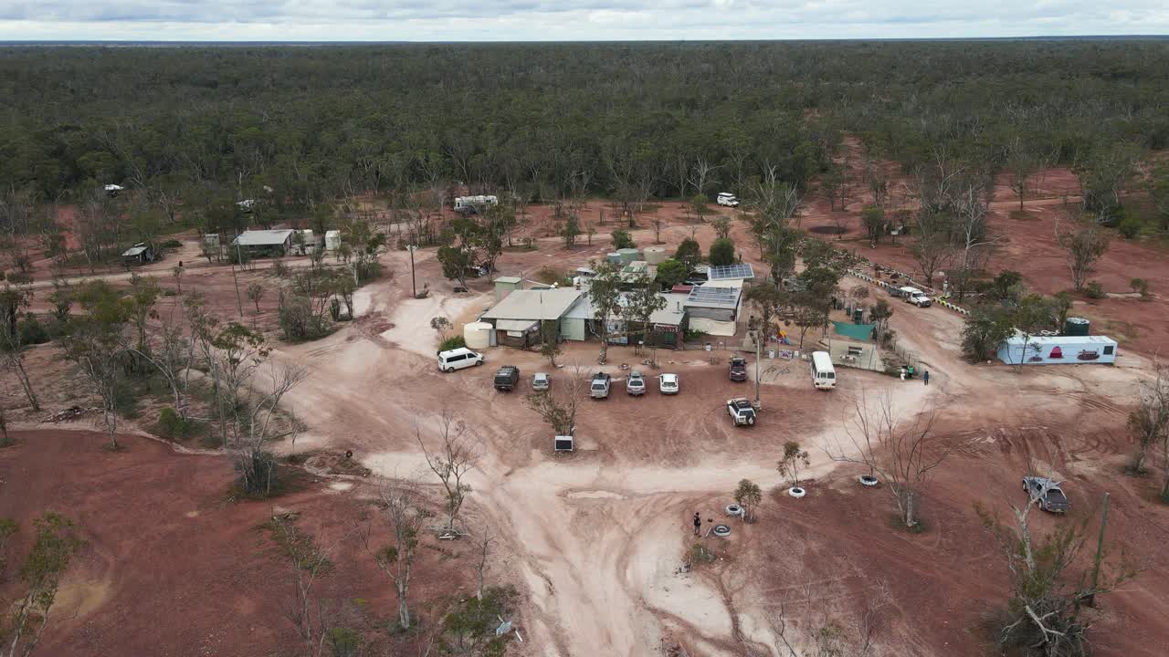 vista aérea de un coche que llega a un viejo pub de minería de ópalo en el interior de australia