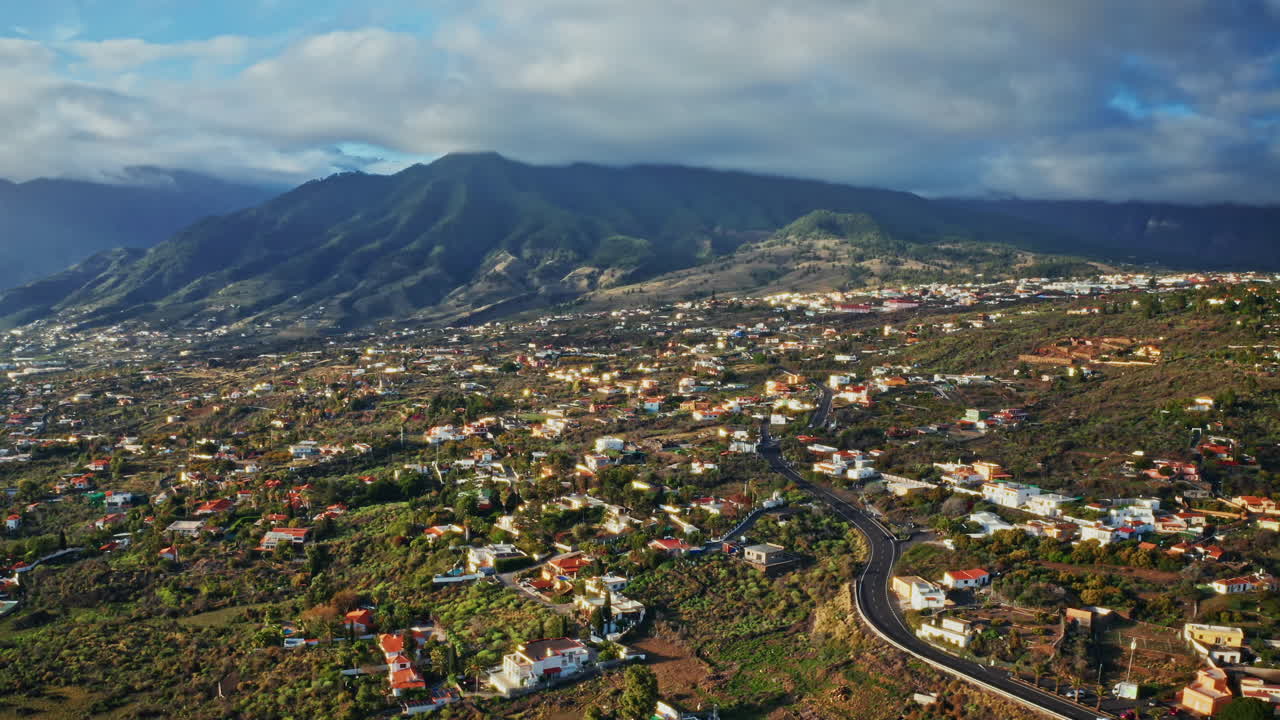 스페인 카나리아 제도 라팔마의 아름다운 풍경의 공중 드론 촬영 - 작은 지역 마을, 초록색 울창한 식물 및 배경의 웅장한 산의 높은 전망.