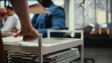 vertical video professional archivist uses rolling trolley to transport documents