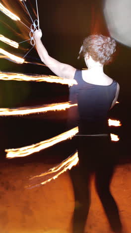 a woman does a fire performance in vertical