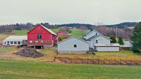 norwegian farmhouse by the green fields with traditional wooden fence in norway. - aerial shot