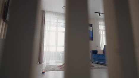 a young woman in isolation does yoga at home on a mat in her apartment