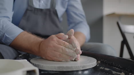 close-up of the hand of a male potter making a ceramic plate in slow motion