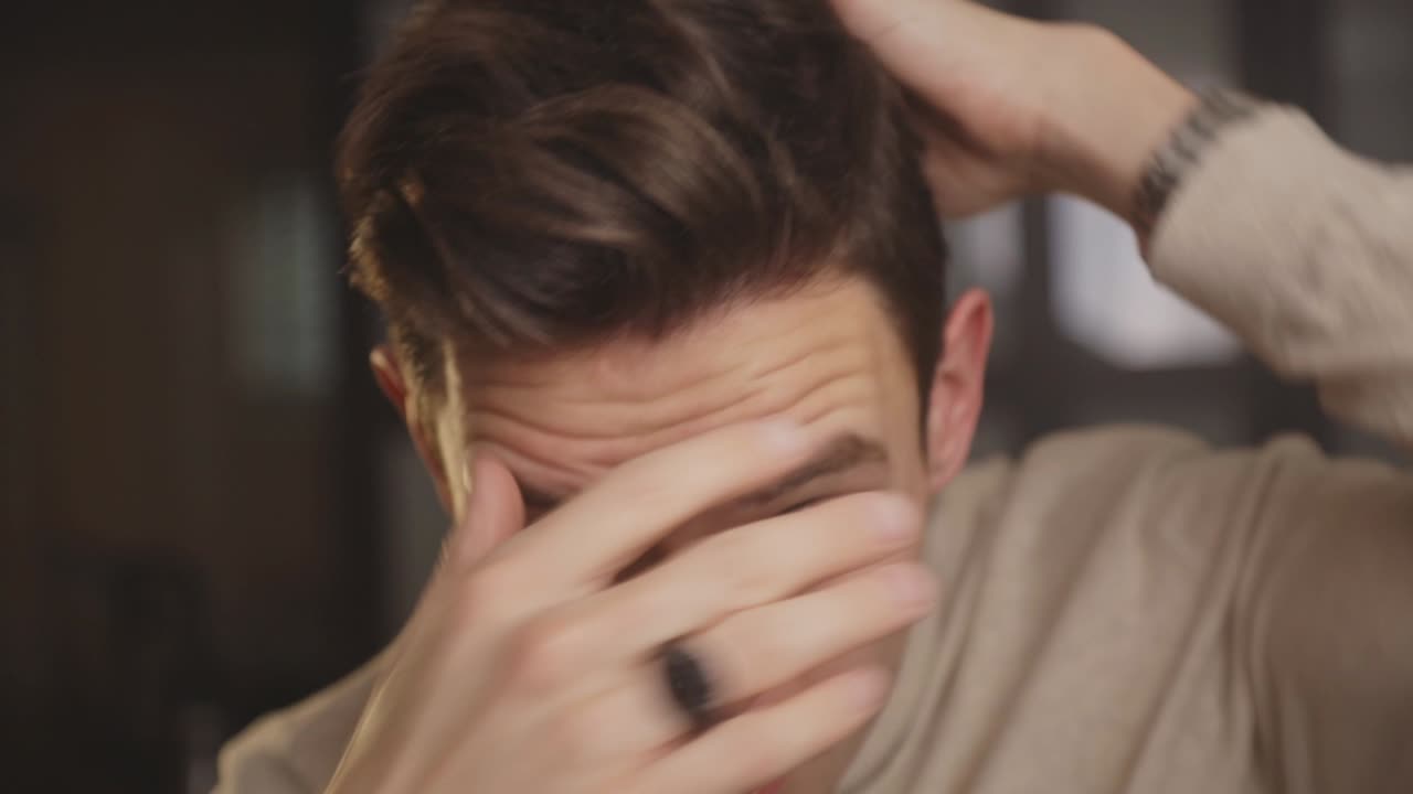 집에서 손으로 머리를 고정하는 백인 남자