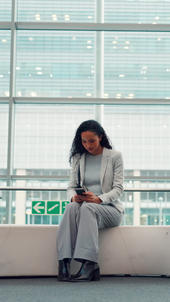 Donna professionista che usa lo smartphone in una moderna sala d'attesa dell'aeroporto