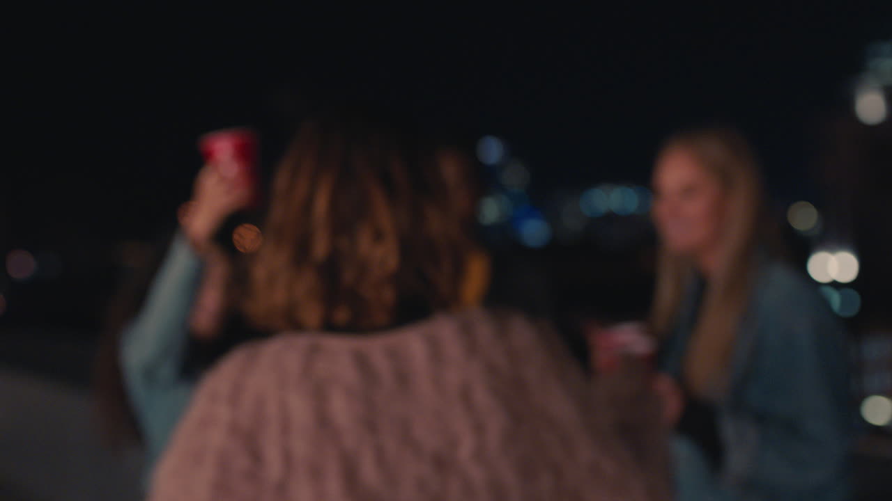 hermosa mujer caucásica besándose con la cámara amigos bebiendo alcohol juntos haciendo brindis disfrutando de la reunión de amistad pasando el rato en la fiesta de la azotea por la noche