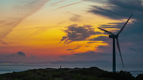 time lapse of windmill spinning against colorful dusky sky at evening