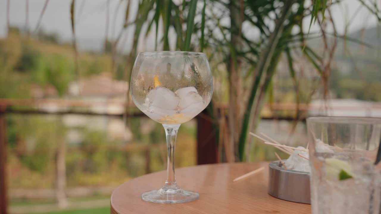 refrescante copa de cóctel con hielo y cítricos en un ambiente cálido al aire libre