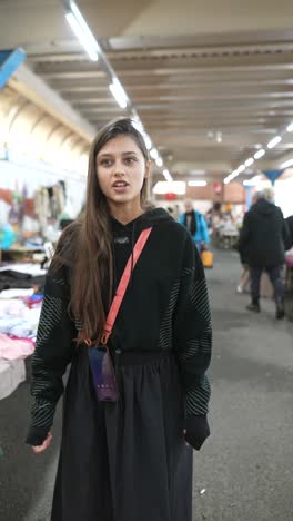 young woman walking through a clothing market