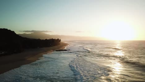 north shore coast of oahu, hawaii at sunset, aerial tilt-up