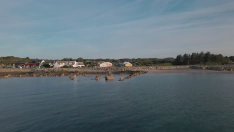 Drone-shot-over-the-sea-flying-towards-Spiddal-village,-Ireland