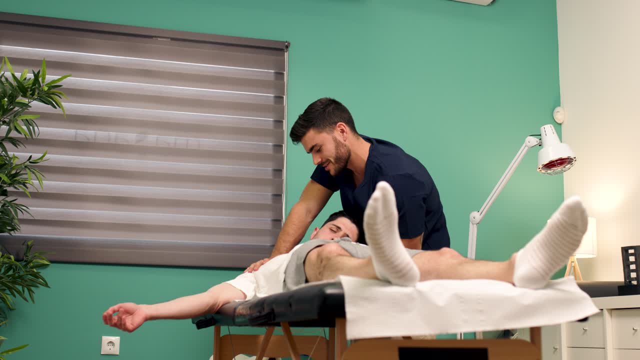 Physiotherapist Massaging Patient's Shoulder in a Modern Clinic