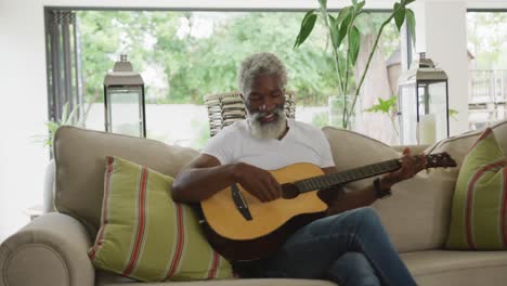 video of sad african american senior man playing the guitar