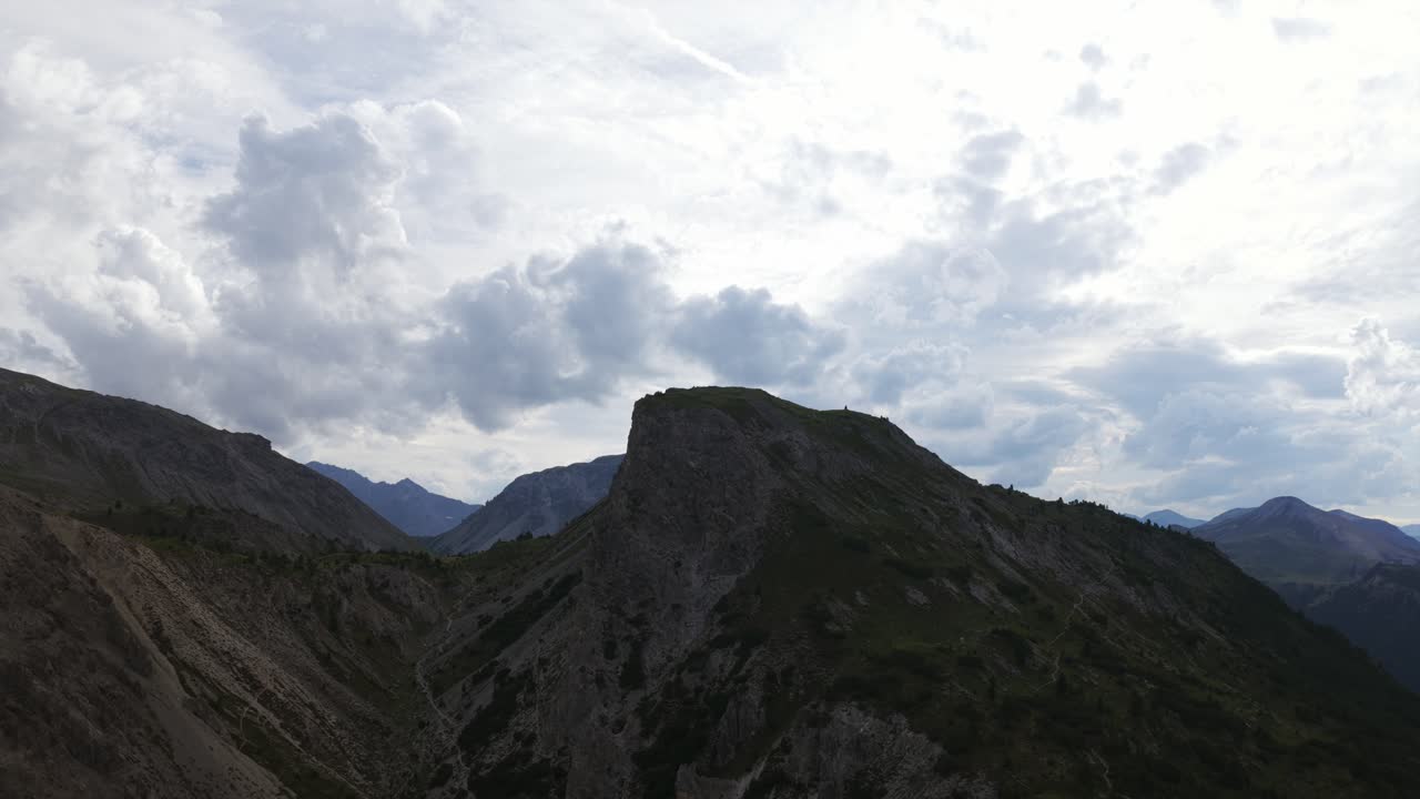 Timelapse of dramatic clouds moving over silhouetted mountain peak at Ofen Pass in Swiss National Park, Switzerland