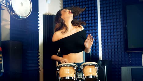 woman playing drums in a professional recording studio.