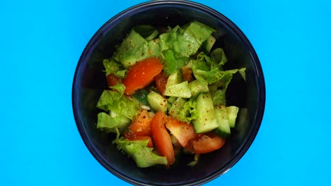 bowl of salad rotates on red background. salad with fresh vegetables. healthy food concept