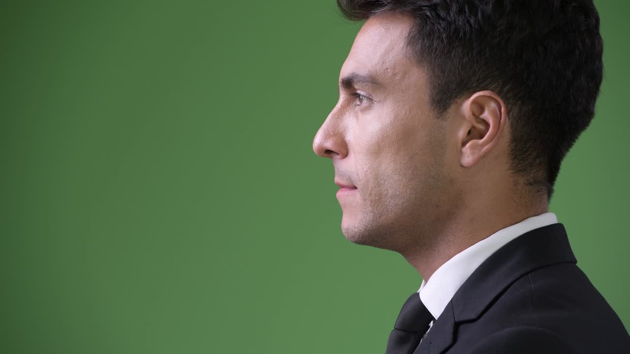 초록색 배경에 젊은 잘생긴 히스패닉 사업가