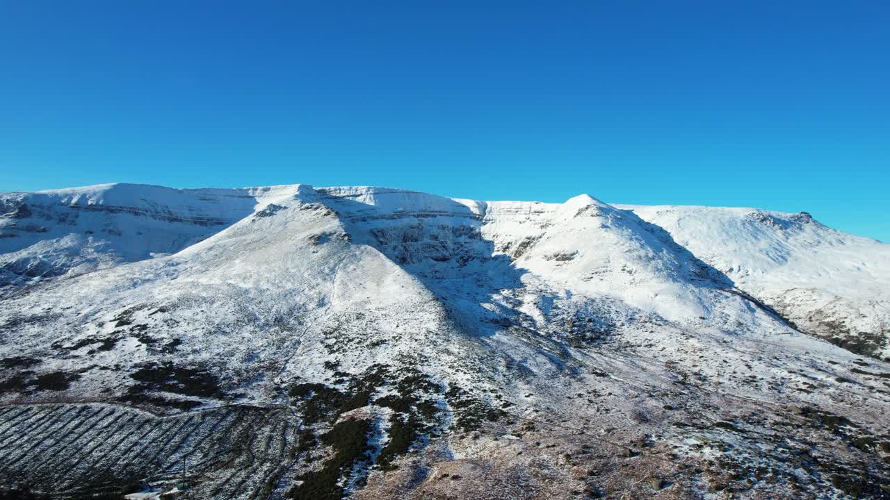 Drone rising shot snow covered Comeragh Mountains on a perfect winter afternoon Epic Locations and Landscapes