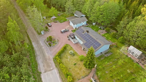 high angle drone shot away from a home with a solar panel roof, summer evening