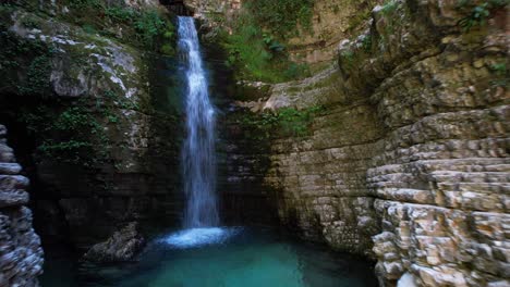 toma cinematográfica de una cascada dentro del agujero del cañón con laderas rocosas en albania