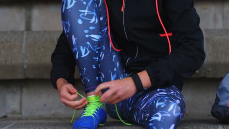 Front-view-of-young-Caucasian-female-athlete-tying-shoes-at-sport-venue-4k