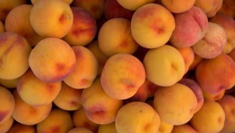 close-up of many peaches on the market. the camera turns and zooms in.