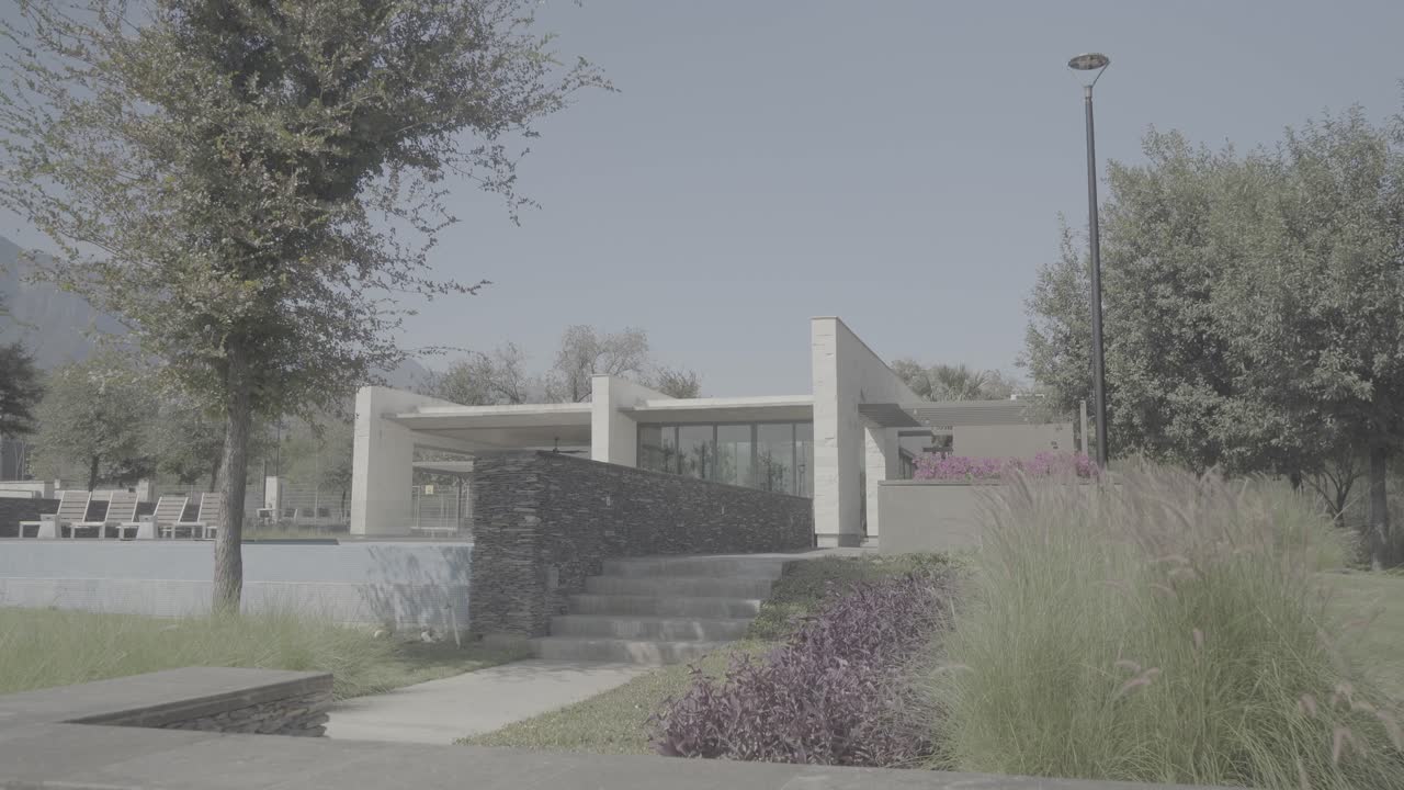 Slow establishing shot of a stone walkway leading up to a private villa