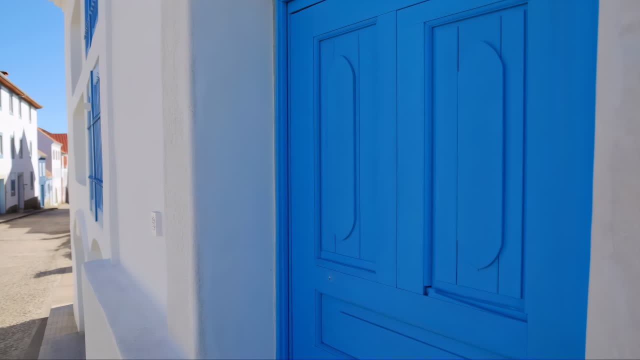 Porta blu vivace su un edificio bianco in una città soleggiata