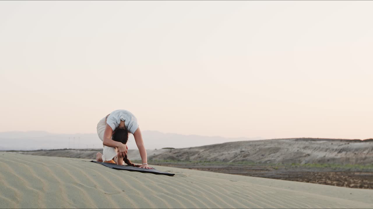 mujer joven realizando una rutina de yoga en las montañas