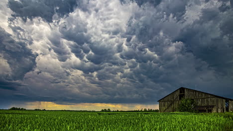 Mammoth-clouds-form-over-a-barn-in-the-countryside---stormy-time-lapse