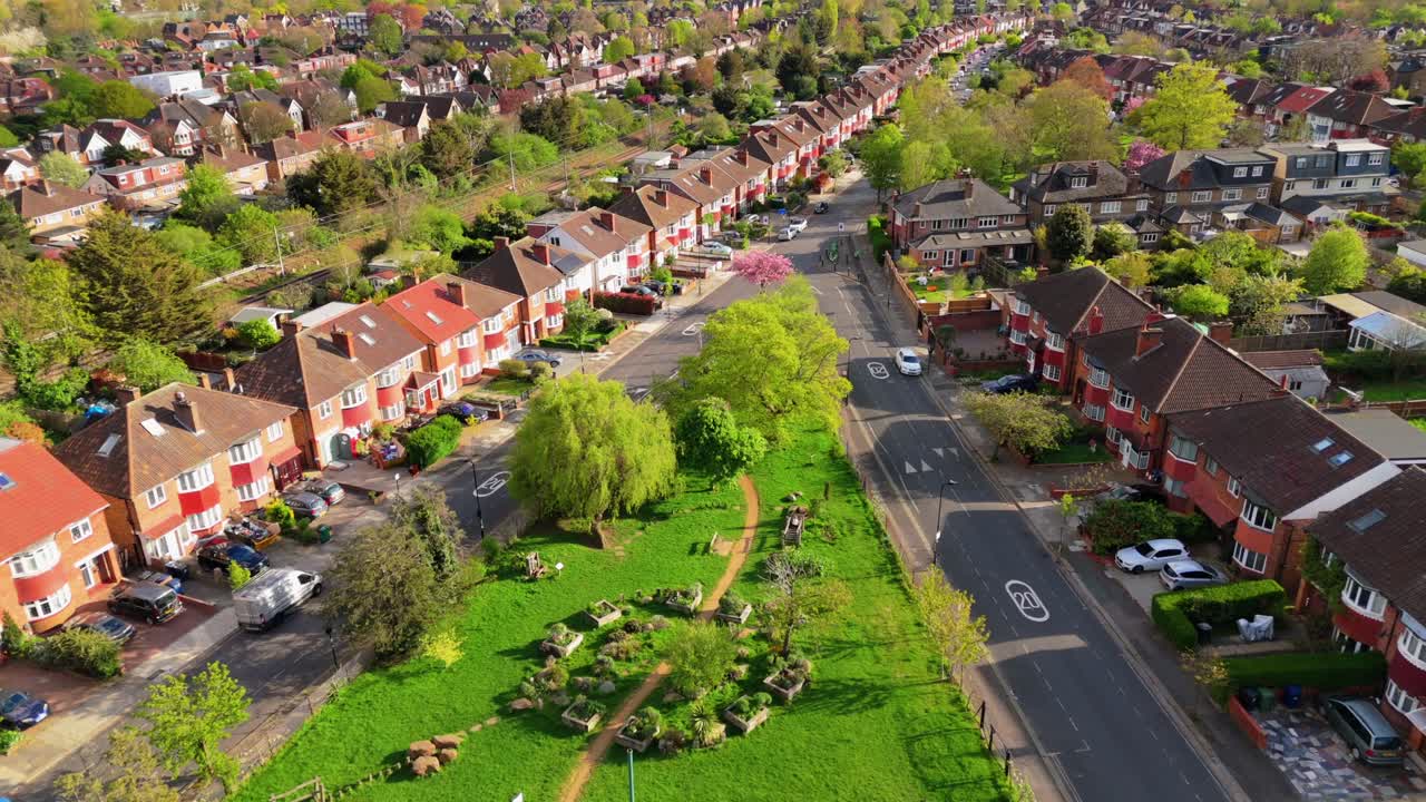 Ripresa con drone di alberi verdi e un parco in una città britannica urbana con un complesso residenziale.