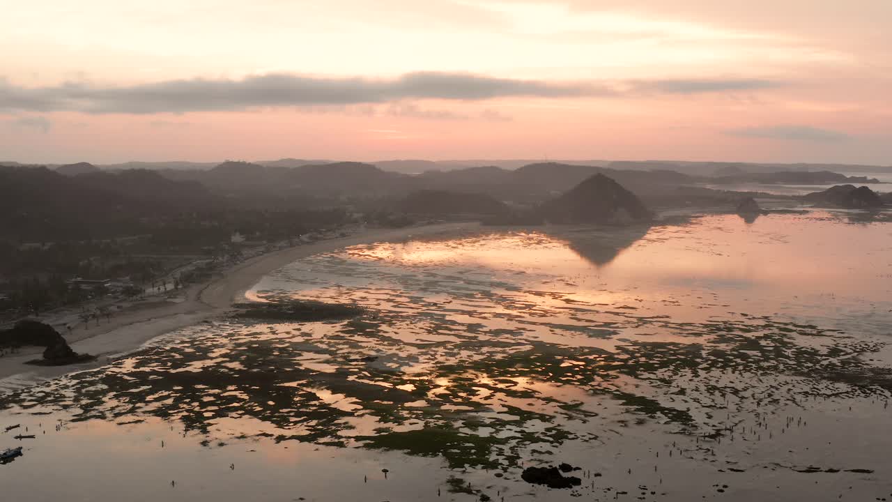 el arrecife seco de kuta lombok durante el amanecer, con gente local buscando comida y conchas marinas