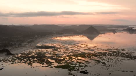 The-dry-reef-of-Kuta-Lombok-during-sunrise,-with-local-people-looking-for-food-and-seashells