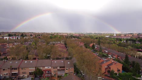 full rainbow after a stormy day over suburbs in pozuelo, madrid, spain