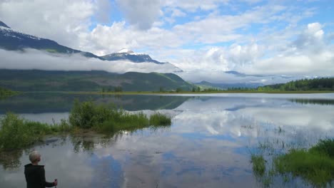 Aerial-view-of-mature-woman-standing-near-a-lake-4k