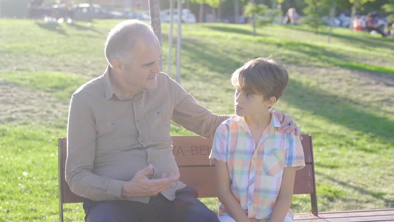 할아버지와 손자가 야외에서 대화를 나누고 있습니다.