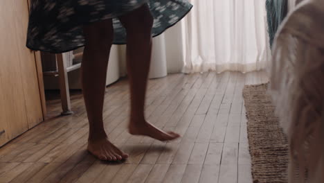 happy young woman dancing at home having fun celebrating summer vacation enjoying playful dance to celebrate successful lifestyle