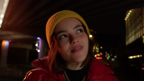 Cheerful-woman-looking-to-city-lights-outdoor.-Pretty-girl-smiling-on-street.
