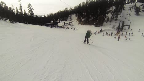 POV-Snowboarder,-Der-Einem-Skifahrer-In-Einer-Grünen-Jacke-Folgt,-Während-Er-Sich-Auf-Den-Weg-Zu-Den-Liftlinien-Macht