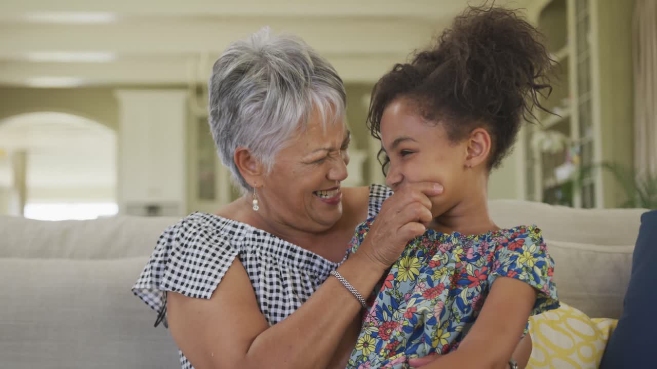 abuela abrazando a su nieta en casa