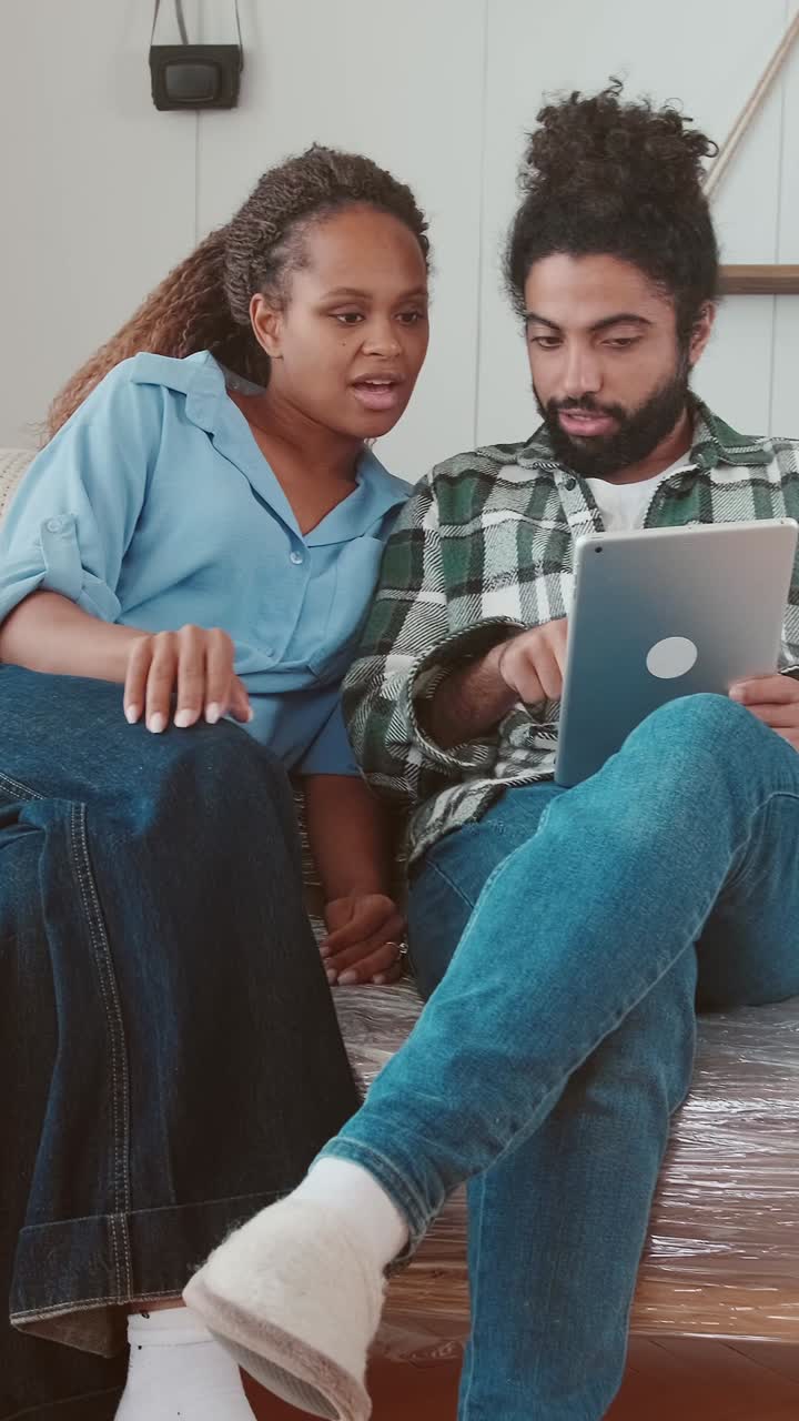 Young woman and man with electronic tablet working together on interior design