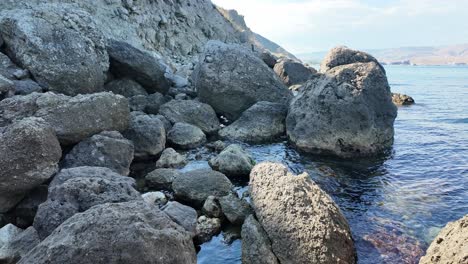 la naturaleza se despliega a medida que las olas chocan suavemente contra las rocas desgastadas a lo largo de la impresionante costa de crimea, revelando la belleza geológica única de la zona y el ambiente sereno.