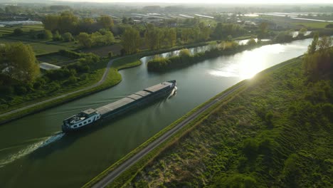 Aerial-view-in-the-sunset-around-à-houseboat-on-a-river-near-Clairmarais,-France