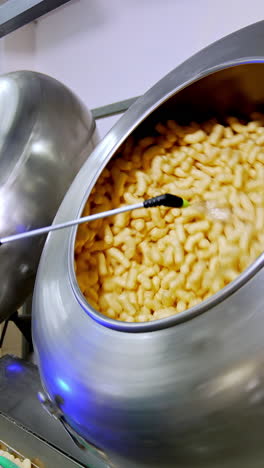 unhealthy puffcorn factory making. industrial snack making for kids. vertical video