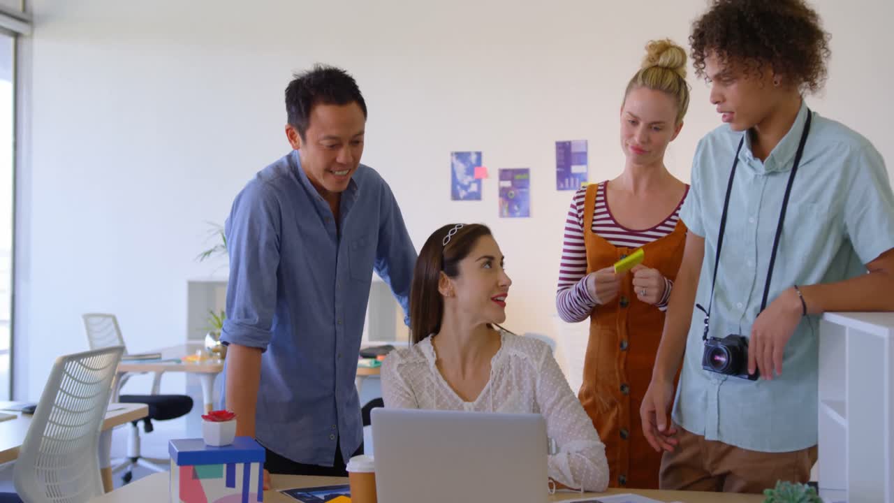 Empresária caucasiana trabalhando em seu laptop com outros profissionais de negócios 4k.