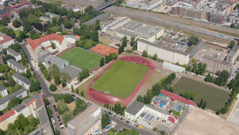 Aerial-view-of-sports-centrum-in-urban-neighbourhood.-Tilt-up-footage-reveal-large-city.-Berlin,-Germany