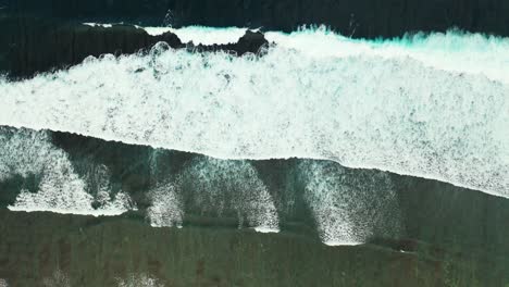 dramatic sea scene with awesome white waves splashing and foaming on sandy shore of tropical island in hawaii