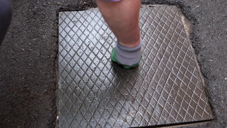 Man-with-green-gloves-and-strong-arm-replaces-manhole-cover