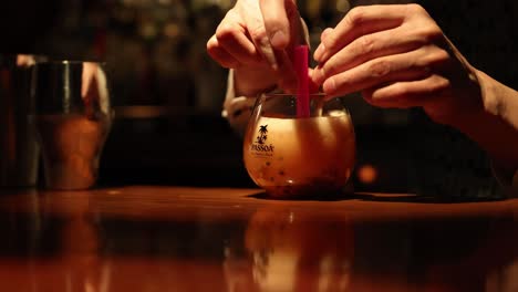 bartender garnishing and serving a cocktail